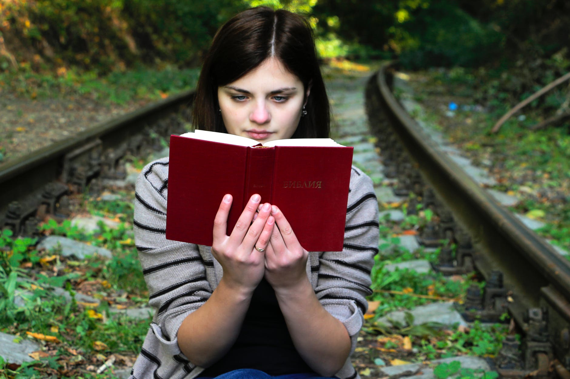 young woman sitting on bench in park