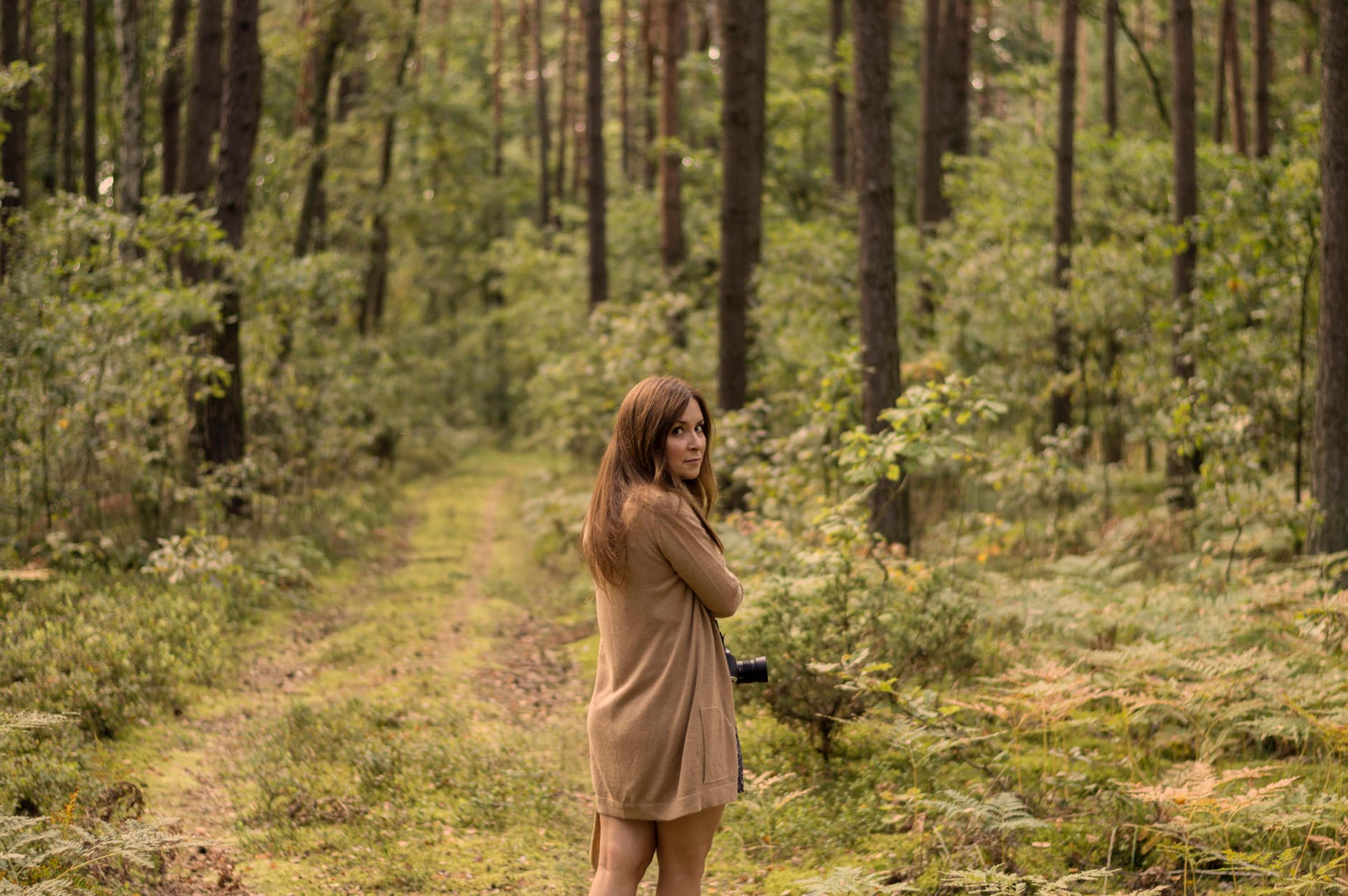 woman standing in the middle of the forest